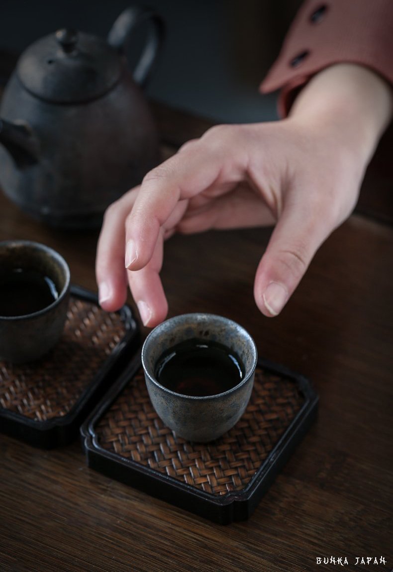 hand-picking-up-Japanese-tea-cups-with-tea